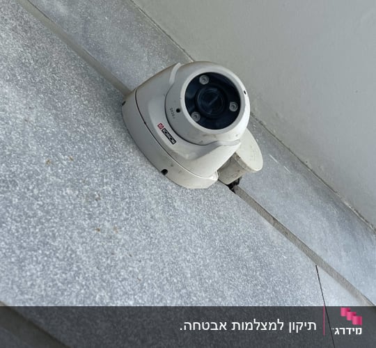 מצלמת אבטחה מותקנת על קיר חיצוני מחופה אריחים